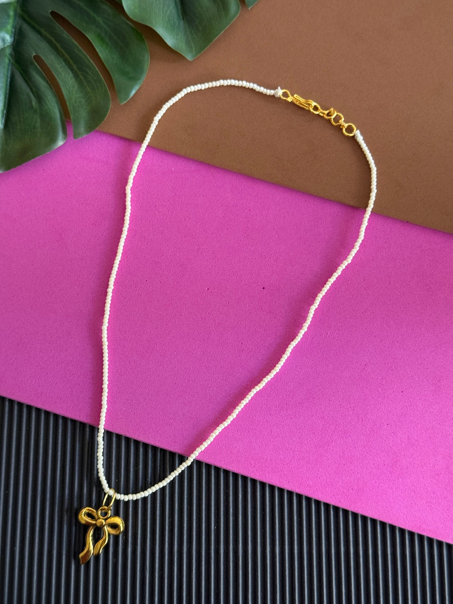 Beaded golden bow charm necklace